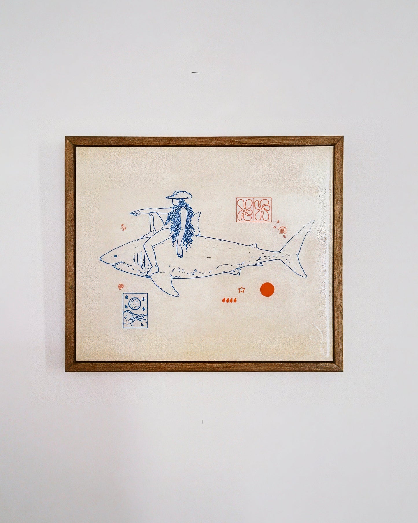 Framed artwork of a person riding a shark on a beige background