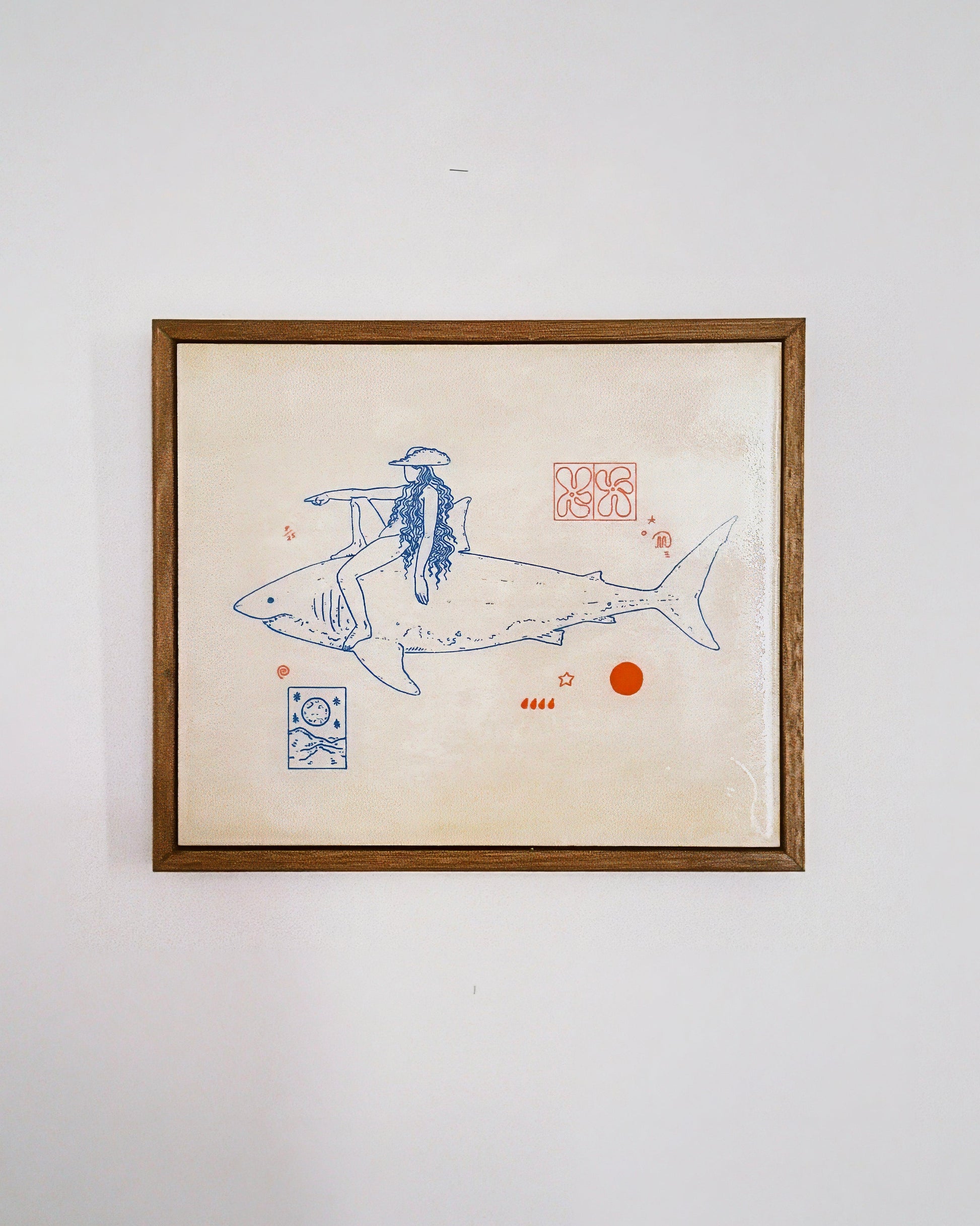 Framed artwork of a person riding a shark on a beige background